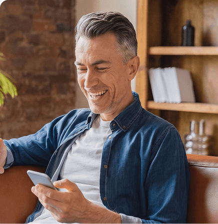 Mann lächelt entspannt mit Smartphone